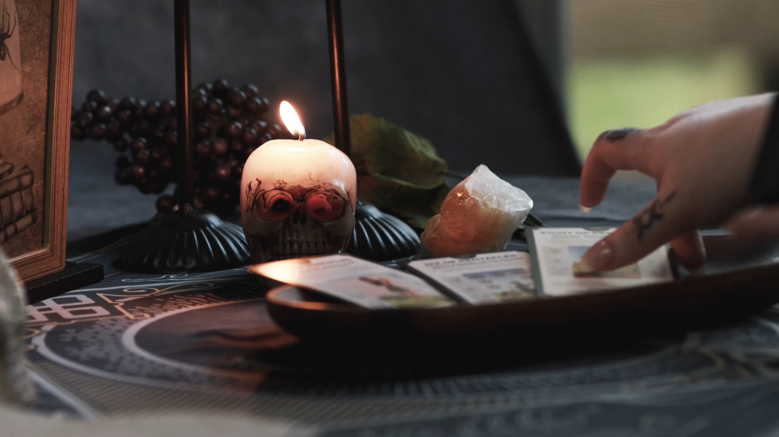 Person conducting a tarot reading with candles and crystals on a table